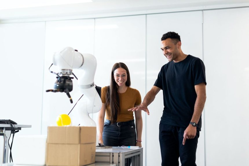 Dois pesquisadores testam um protótipo robótico em um laboratório moderno.